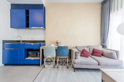 Modern living room with blue kitchen cabinets and cozy sofa