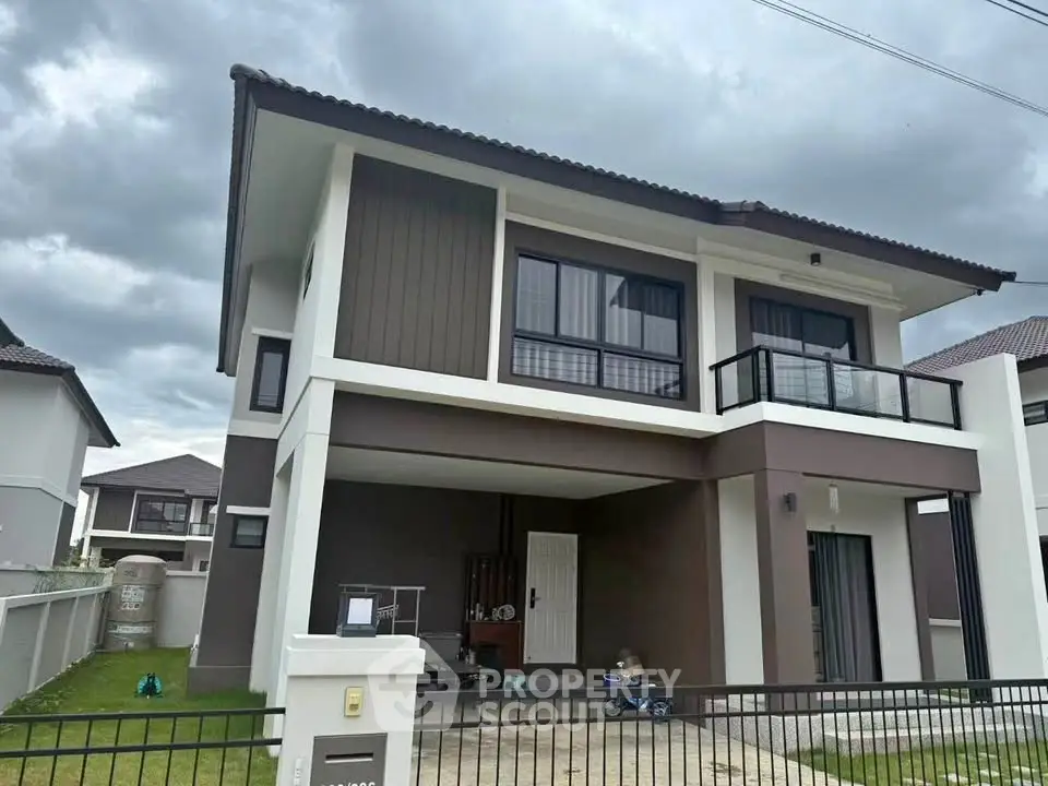 Modern two-story house with sleek design and spacious driveway in a suburban neighborhood.