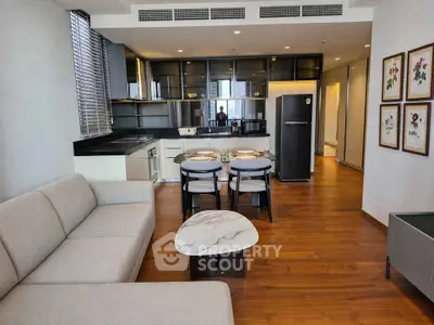 Modern open-plan living room and kitchen with sleek design and wooden flooring.