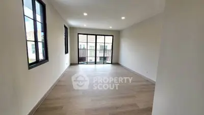 Spacious living room with large windows and balcony access in modern apartment.