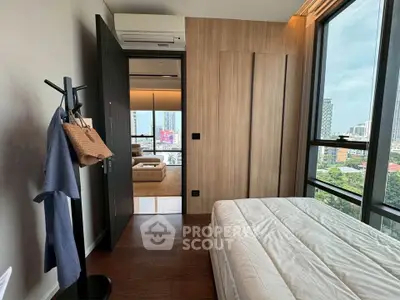 Modern bedroom with city view, featuring wooden accents and large windows for natural light.