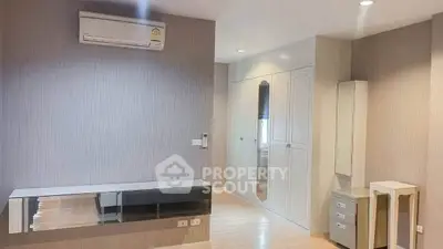 Spacious bedroom with modern built-in wardrobe and air conditioning unit.