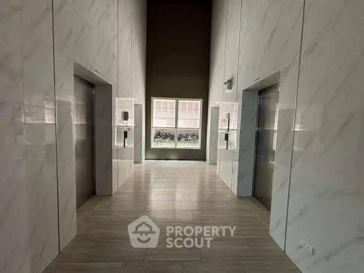 Modern elevator lobby with sleek marble walls and natural light