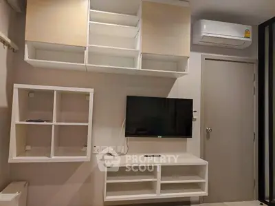 Modern living room with wall-mounted TV and sleek storage cabinets