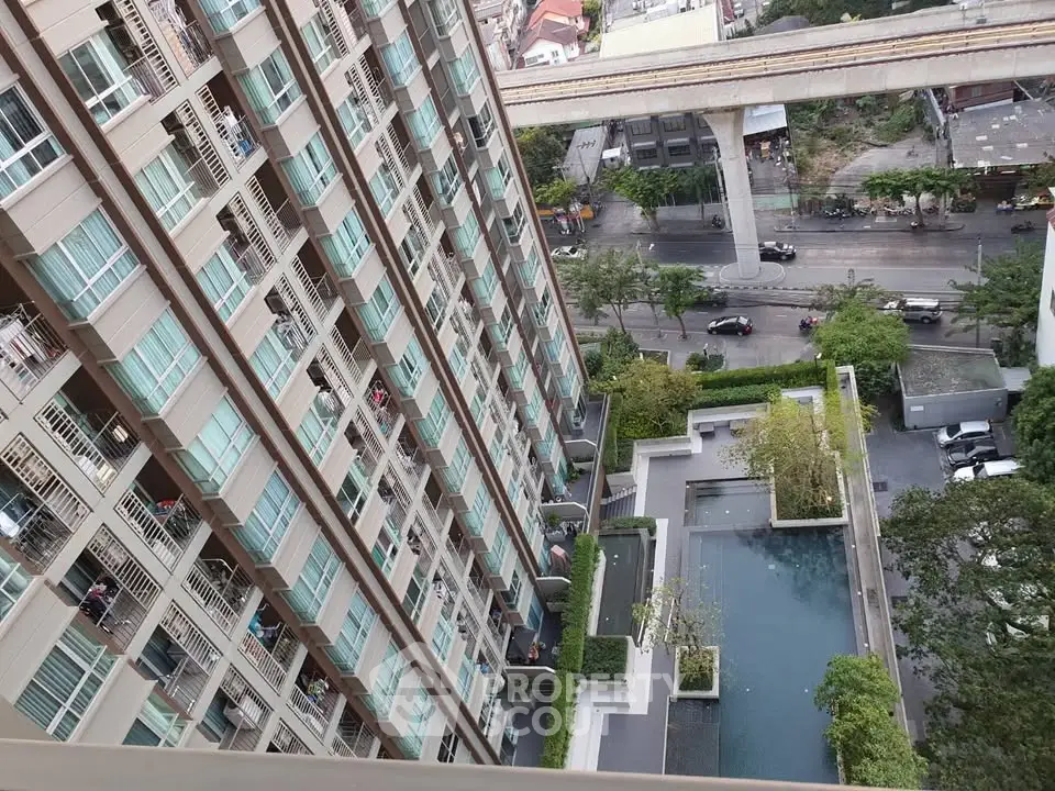 High-rise condominium with pool and city view from upper floor balcony.