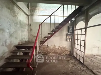 Rustic interior with metal staircase and vintage charm, ideal for renovation enthusiasts.