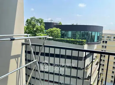 Modern urban balcony view with sleek architecture and lush greenery