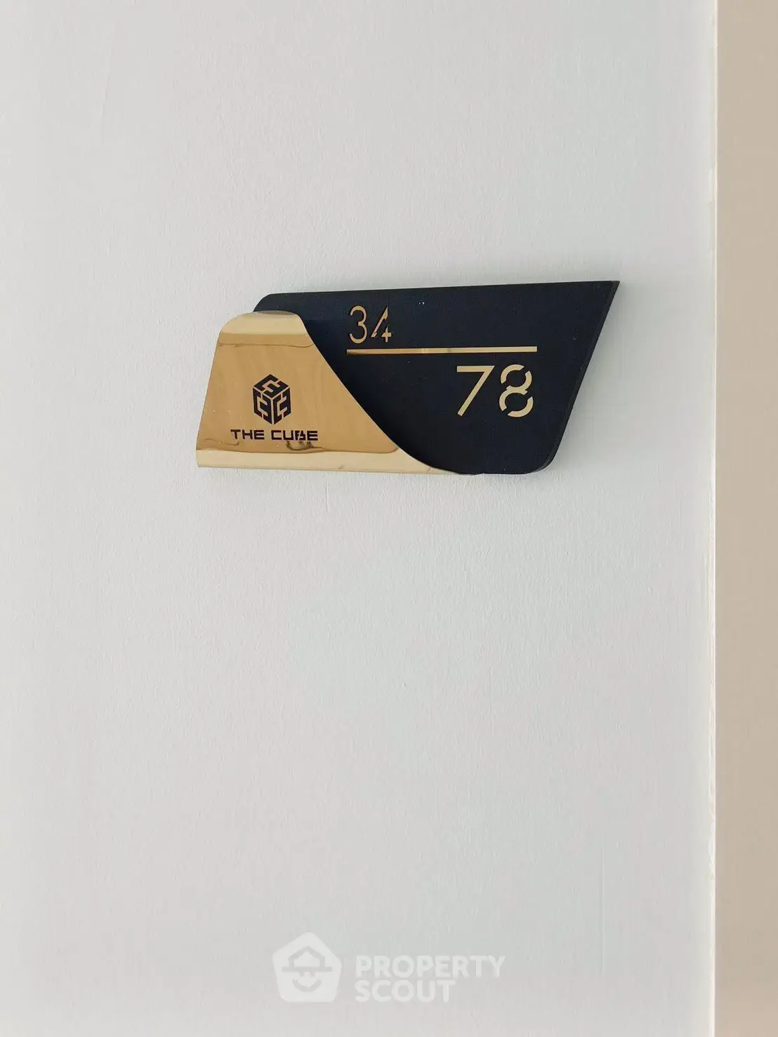 Modern apartment number sign with sleek design at The Cube building.
