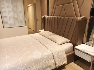 Luxurious bedroom with stylish headboard and elegant bedding in modern apartment.