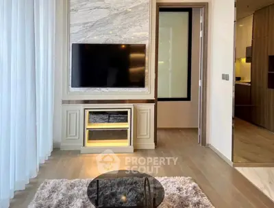 Modern living room with elegant TV setup and cozy rug in stylish apartment.