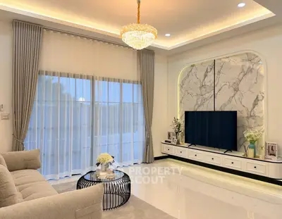 Luxurious living room with elegant chandelier and marble accent wall