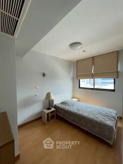 Cozy bedroom with natural light and modern decor, perfect for relaxation.
