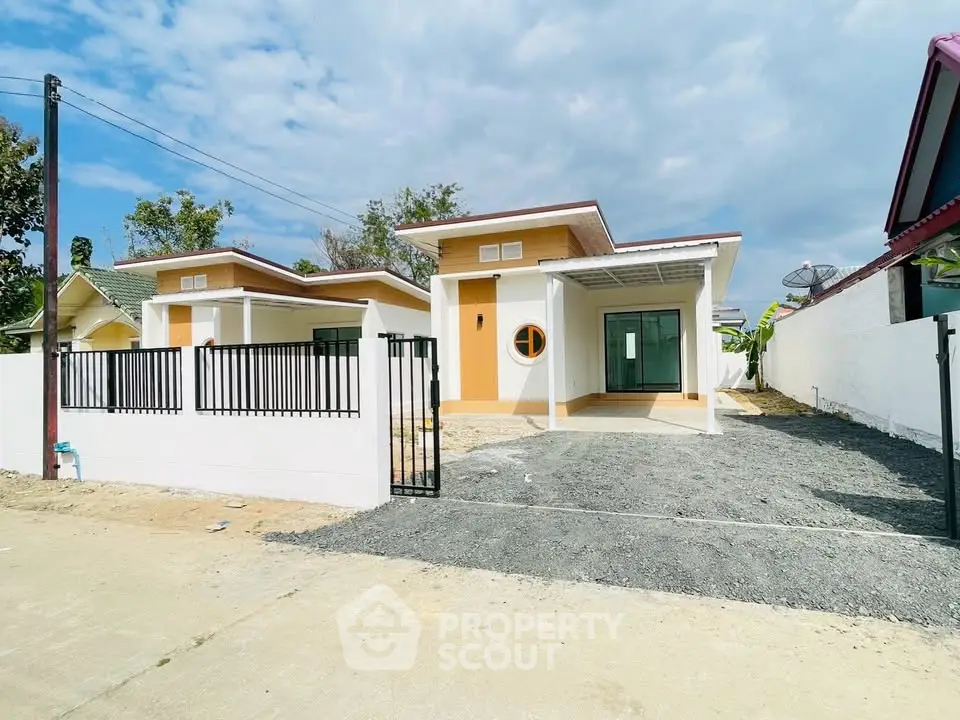 Modern single-story house with unique circular window and spacious driveway