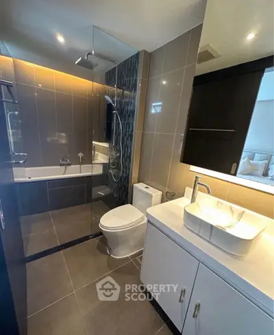 Modern bathroom with sleek design, glass shower, and elegant fixtures in a contemporary apartment.