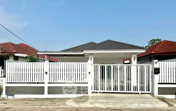Charming single-story home with modern white fence and tiled roof in a serene neighborhood.