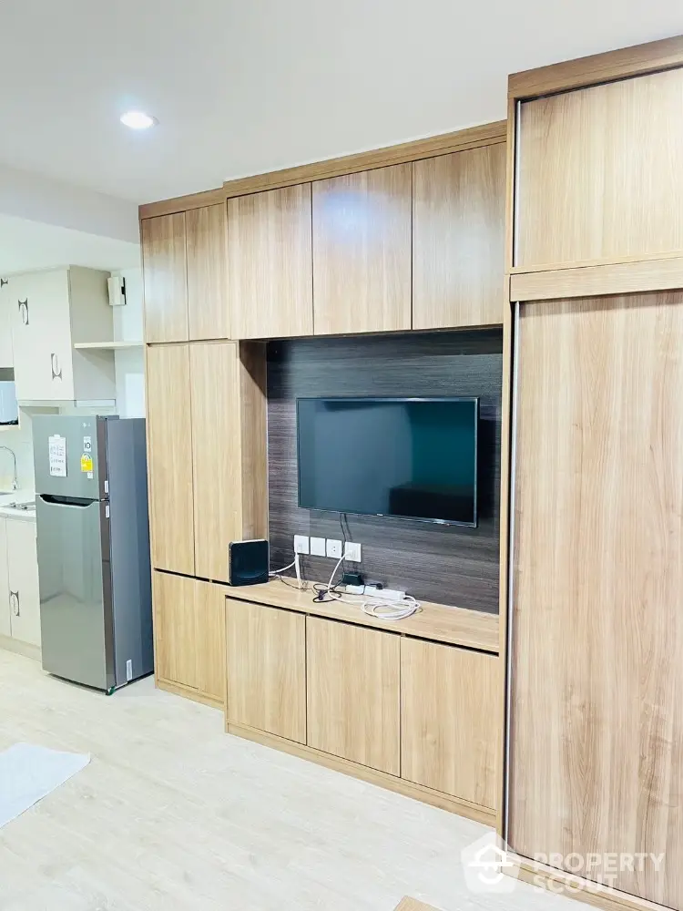 Modern living room with built-in wooden cabinets and flat-screen TV