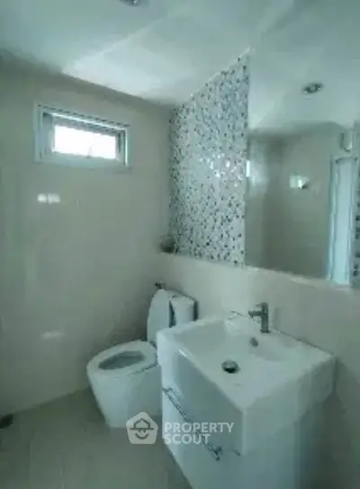 Modern bathroom with sleek fixtures and mosaic tile accent wall