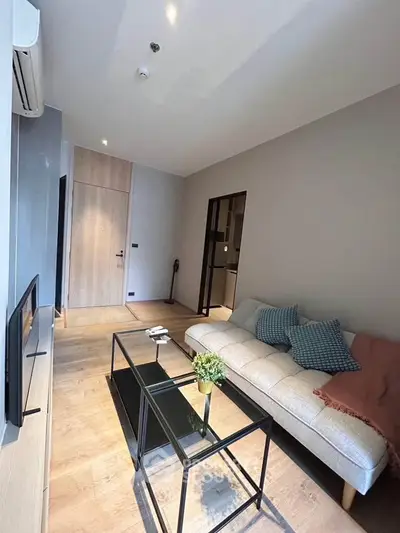 Modern living room with sleek design, featuring a cozy sofa, glass coffee table, and stylish decor.