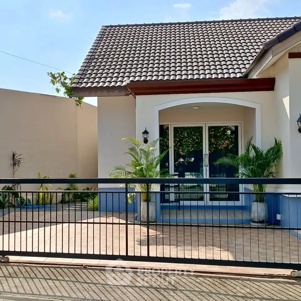 Charming single-story home with tiled roof and inviting front entrance, perfect for family living.