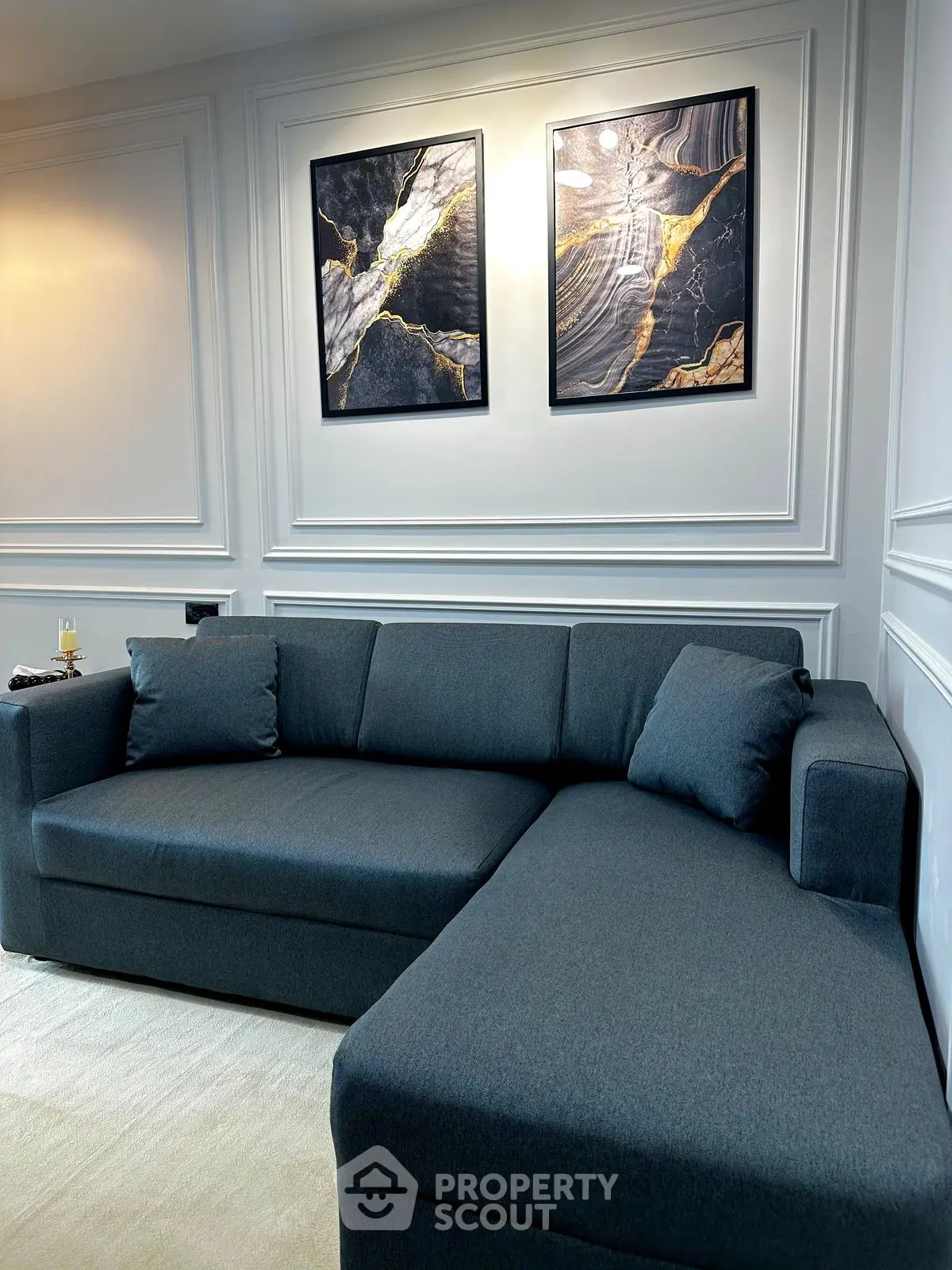 Elegant living room with modern dark sofa and abstract art on wall