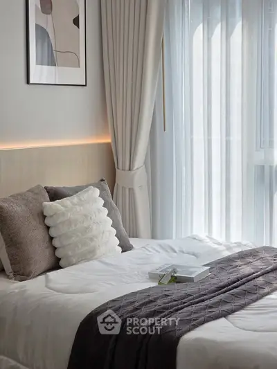 Elegant bedroom with modern decor, featuring plush pillows and soft lighting, perfect for relaxation.