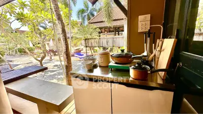 Charming outdoor kitchen with tropical garden view, perfect for al fresco dining and relaxation.