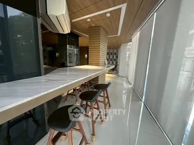 Modern kitchen with sleek design and bar seating, featuring wood accents and natural light.
