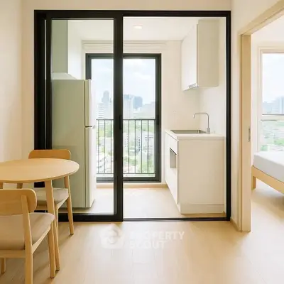 Modern apartment with compact kitchen and city view from balcony.