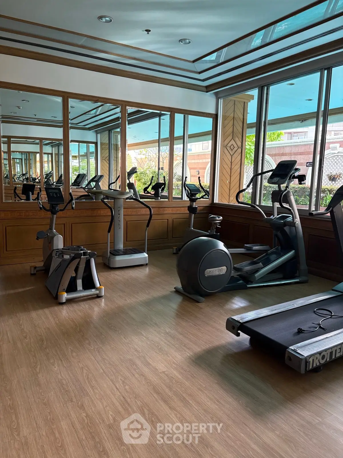 Spacious gym with modern exercise equipment and large windows