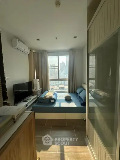 Cozy bedroom with city view, modern furnishings, and ample natural light.