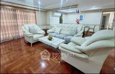 Spacious living room with elegant furniture and wooden flooring, perfect for relaxation and entertainment.