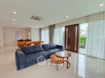Spacious modern living room with elegant furniture and large windows offering natural light.