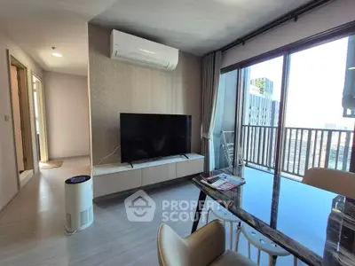 Modern living room with large TV, air conditioning, and balcony view in a stylish apartment.