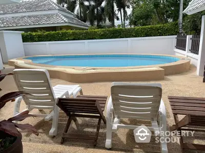 Charming private pool area with sun loungers and lush greenery, perfect for relaxation.