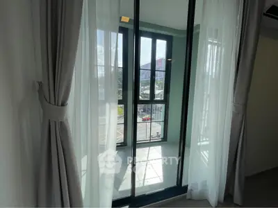 Bright balcony with floor-to-ceiling windows offering a stunning city view, perfect for relaxation.
