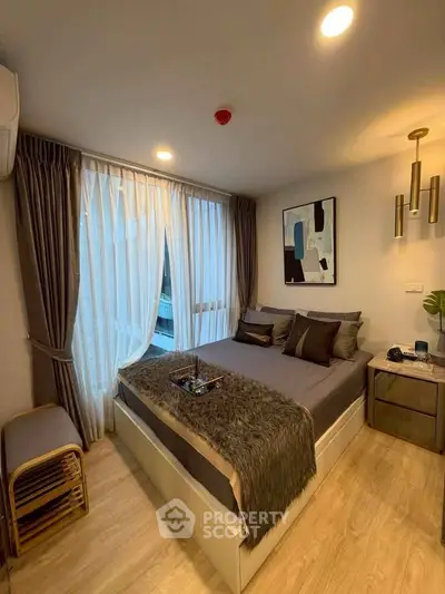Cozy modern bedroom with stylish decor and large window for natural light.