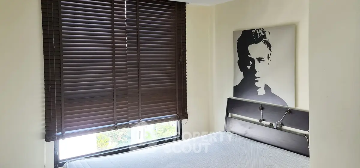 Cozy bedroom with modern blinds and stylish wall art, perfect for urban living.