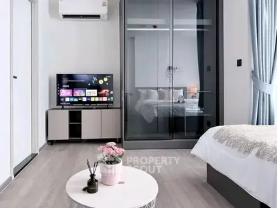 Modern bedroom with glass partition, TV, and stylish decor