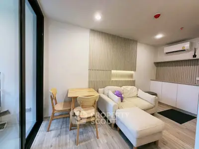 Modern living room with cozy seating and dining area, featuring sleek design and natural light.