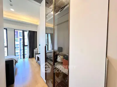 Modern bedroom with floor-to-ceiling windows and sleek storage solutions in a high-rise apartment.