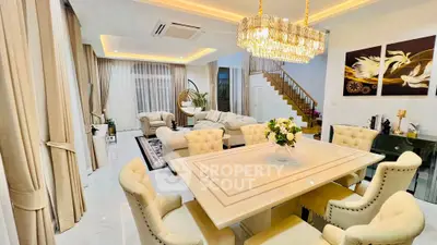 Luxurious open-plan living and dining area with elegant chandelier and plush seating.