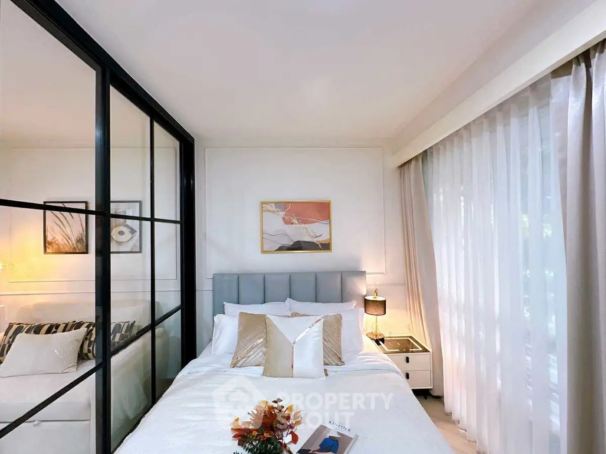 Stylish bedroom with modern decor and large window for natural light.