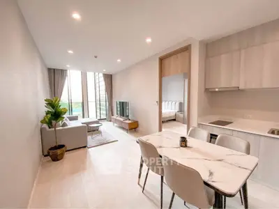 Modern open-plan living room with dining area and kitchen in a bright apartment
