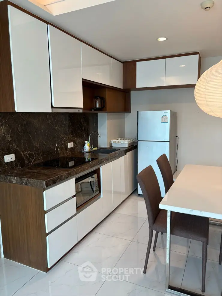 Modern kitchen with sleek cabinets and dining area in stylish apartment