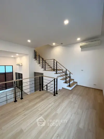 Spacious modern living room with sleek staircase and wooden flooring