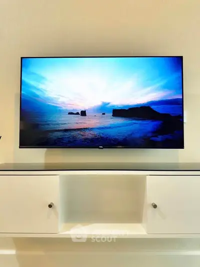 Modern living room with sleek TV and minimalist white cabinet