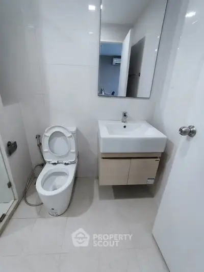 Modern bathroom with sleek fixtures and minimalist design, featuring a wall-mounted sink and toilet.