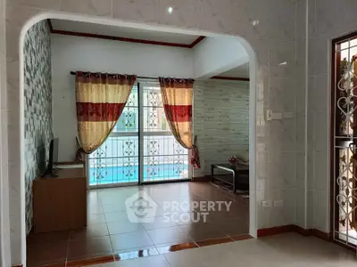 Spacious living room with elegant curtains and tiled flooring, perfect for cozy family gatherings.