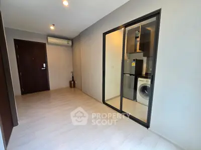 Modern apartment interior with sleek kitchen and washing machine, featuring minimalist design and ample natural light.