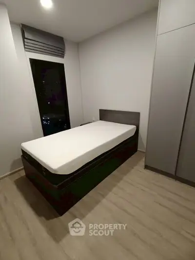 Modern minimalist bedroom with single bed and sleek wardrobe